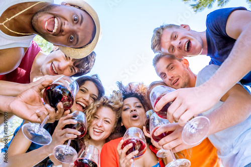 group of friends huddle, cheers with wine glasses