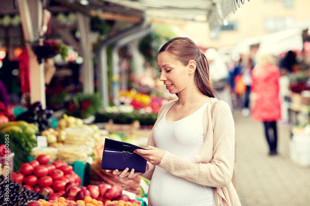pregnant woman with wallet buying food at market
