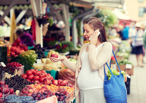 pregnant woman calling on smartphone at market
