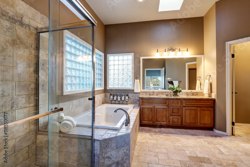 Luxury bathroom interior with vanity with granite counter top  large mirror and tile floor.