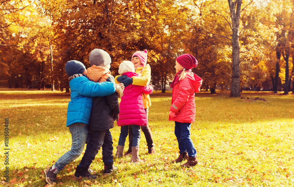 group of happy children hugging in autumn park group of happy children hugging in autumn park