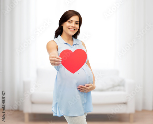 happy pregnant woman with red heart touching belly