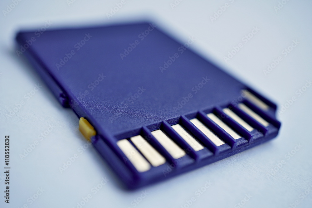 Isolated plastic compact memory card (SD card - Secure Digital card) used in cameras, computers and video cameras in a blue color with metal connectors in the golden color Isolated plastic compact memory card (SD card - Secure Digital card) used in cameras, computers and video cameras in a blue color with metal connectors in the golden color