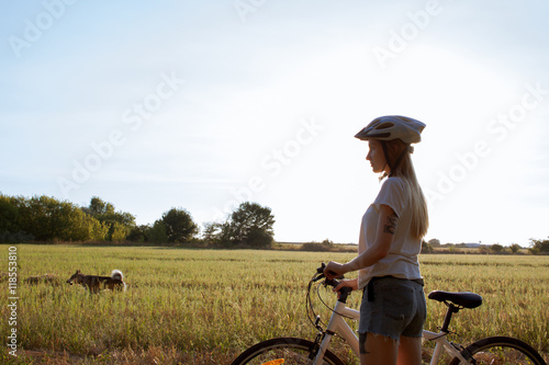 young woman with bicycle in helmet 