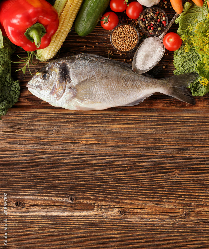 Fresh raw fish with vegetables on old wooden background Fresh raw fish with vegetables on old wooden background