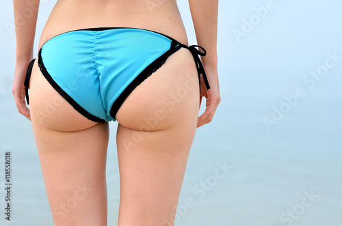 Young woman with big and sexy booty on sea background.