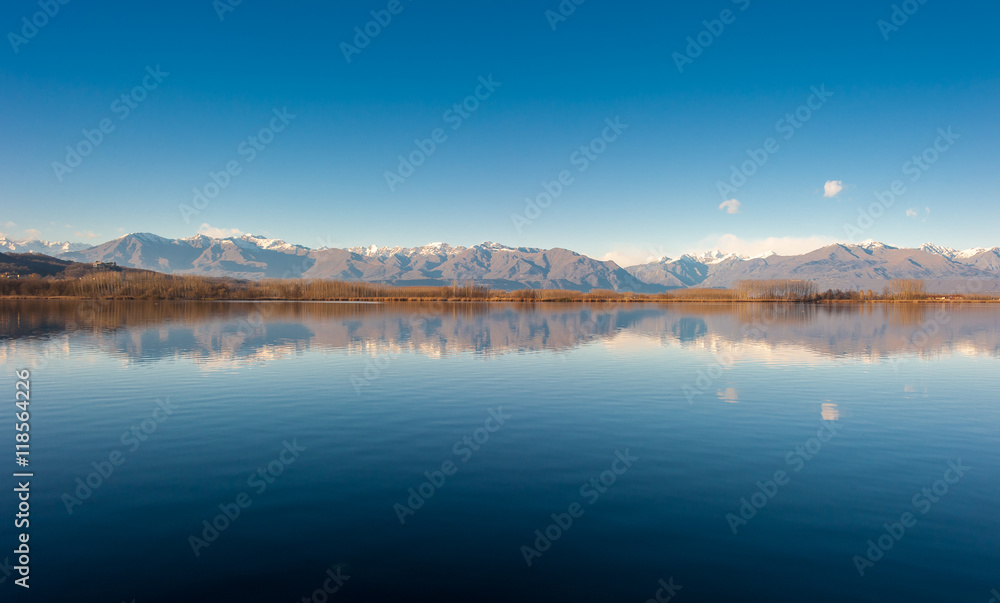 Fototapeta premium Quiet mountain lake horizon with hills and blue sky