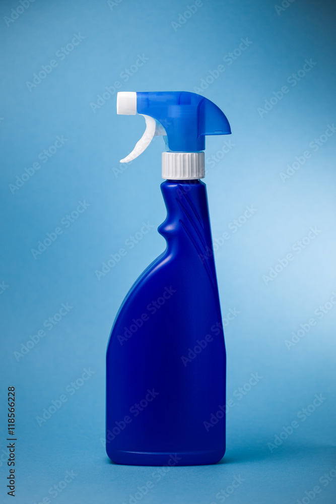 Sprühflasche für Reinigungsmittel vor blauem Hintergrund Sprühflasche für Reinigungsmittel vor blauem Hintergrund