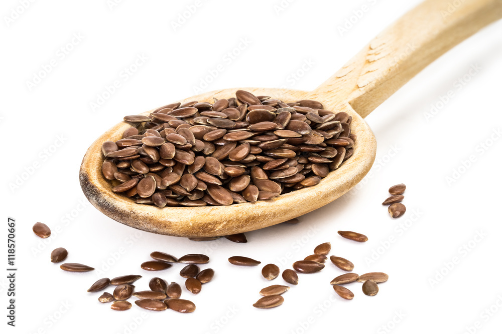 Fototapeta premium Linseed on a wooden spoon seen from the front on white background