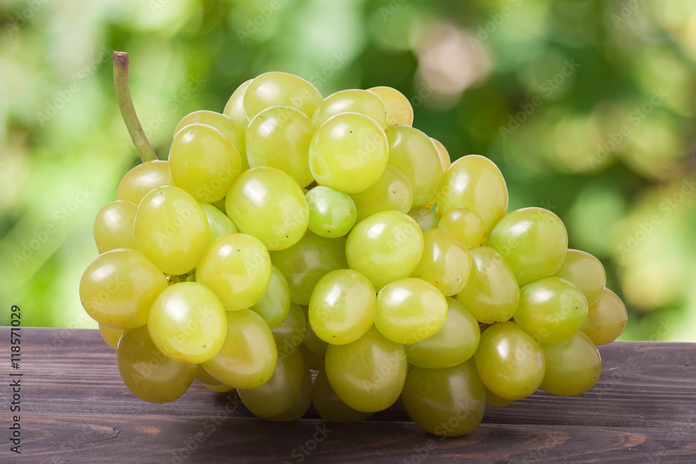 bunch of ripe green grapes on a wooden table with blurred background bunch of ripe green grapes on a wooden table with blurred background
