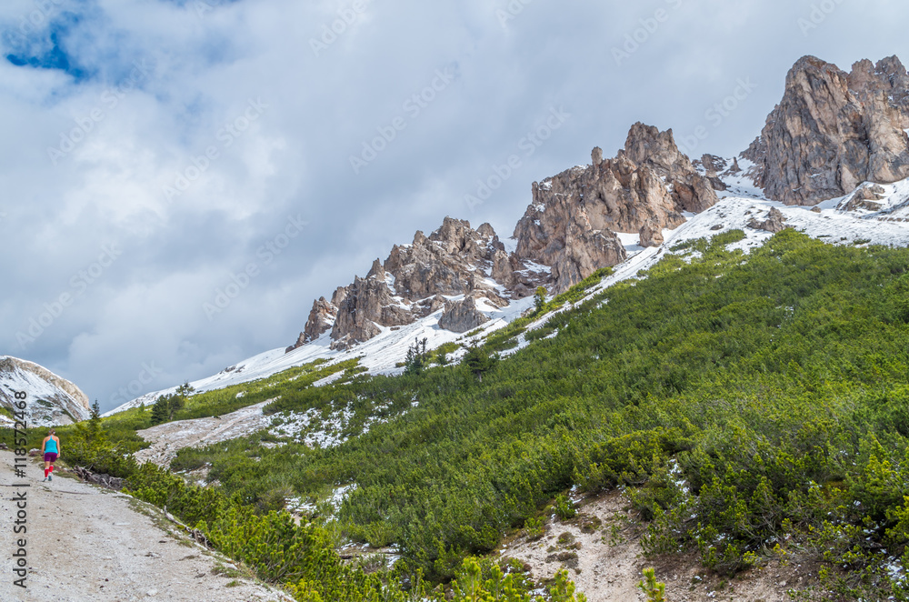 Female trailrunning in the mountains of dolomites Val Gardena, Italy