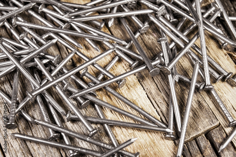 Steel shiny nails on wooden background. Stock image macro. Steel shiny nails on wooden background. Stock image macro.