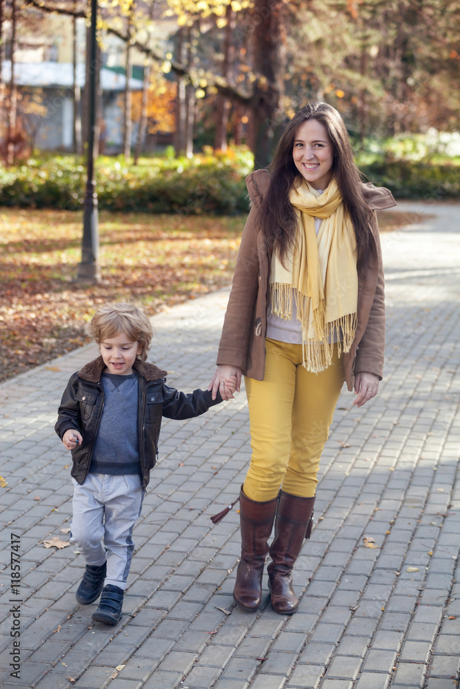 Happy mother and son walking in autumn.