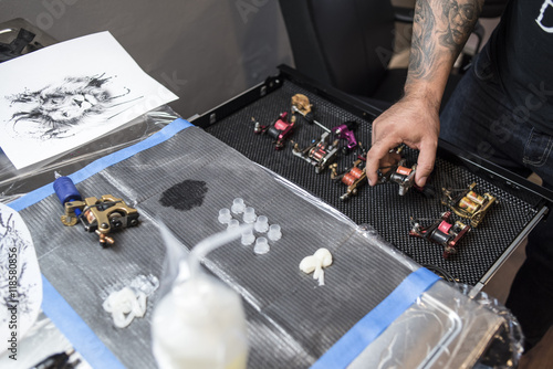 Billede på lærred Tattooer chasing his tattoo machine
