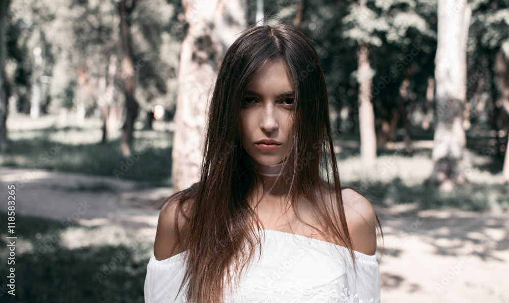 Portrait of beautiful sexy girls with dark hair and bare shoulders seductively in park Portrait of beautiful sexy girls with dark hair and bare shoulders seductively in park