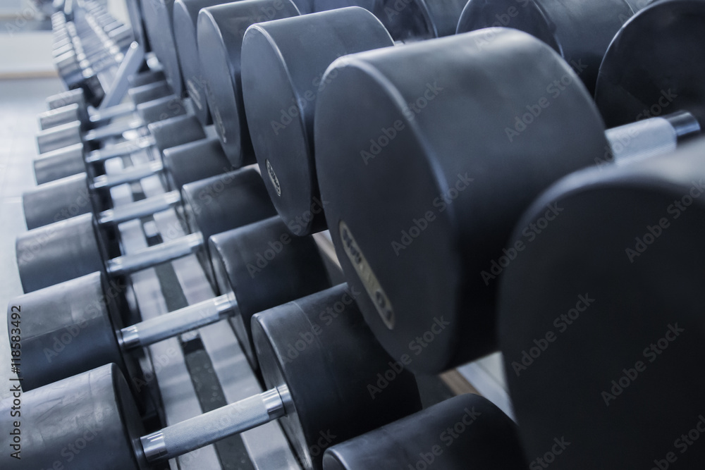 Obraz premium Dumbbells in the gym Dumbbells lined up in a fitness studio. picture is short focus