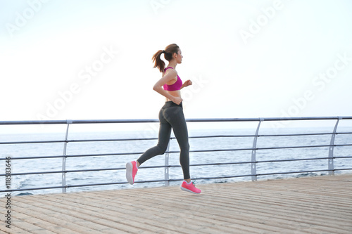 Young woman running on pier