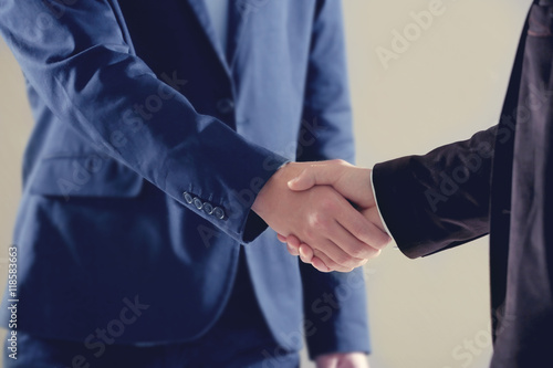 Businessmen shaking hands on grey background