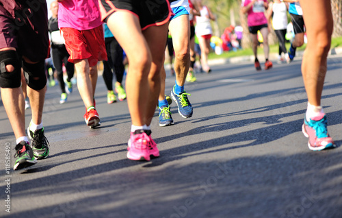 Unidentified marathon athletes legs running on city road © lzf