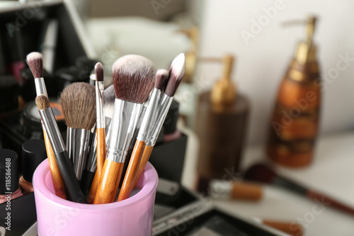 Set of make-up brushes and decorative cosmetics on blurred background