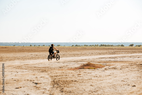Man rides his motorcycle through the desert