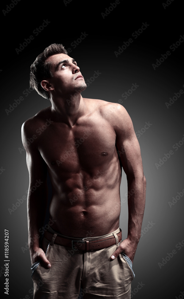 Fototapeta premium a young male model posing his muscles