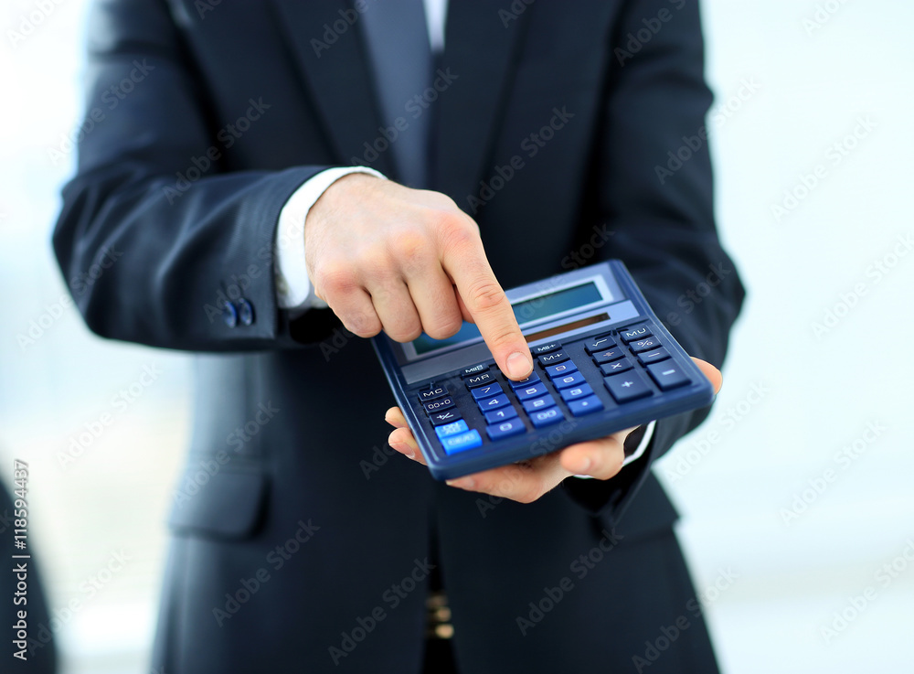 businessman uses a calculator for calculations businessman uses a calculator for calculations