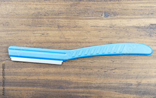 A blue plastic handle of a razor which just shaved of women eyebrow