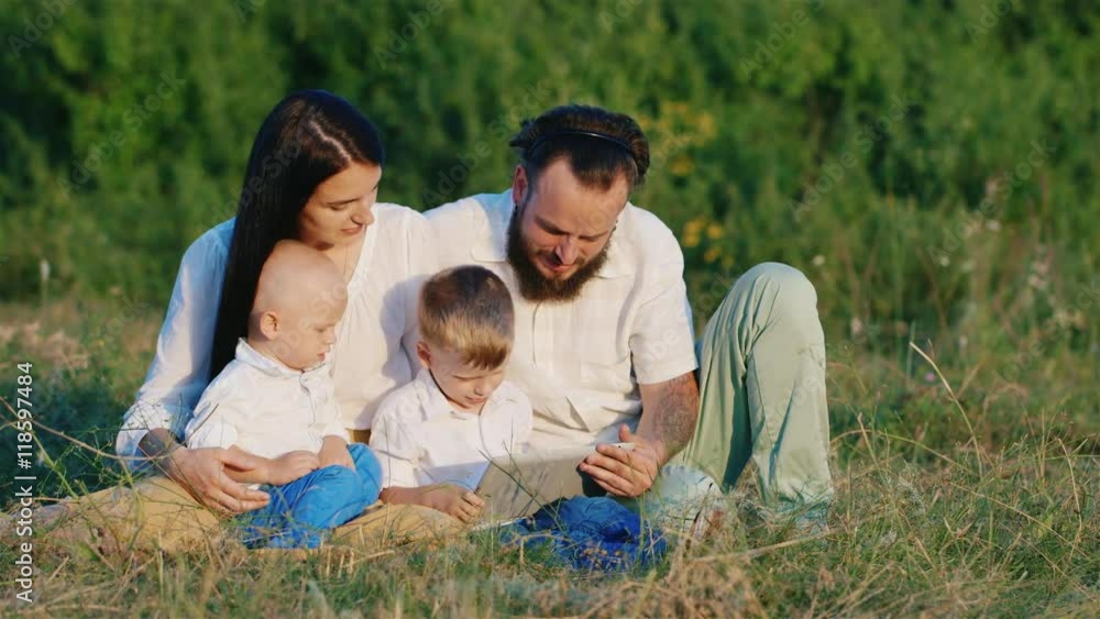 Young family on holiday with his two sons. Watch the video on your tablet Young family on holiday with his two sons. Watch the video on your tablet