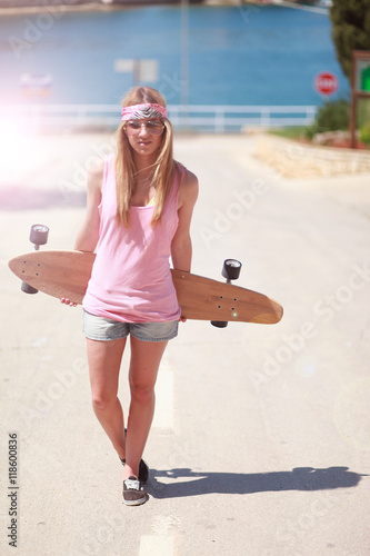 Skatergirl auf der Strasse vor dem Meer photo