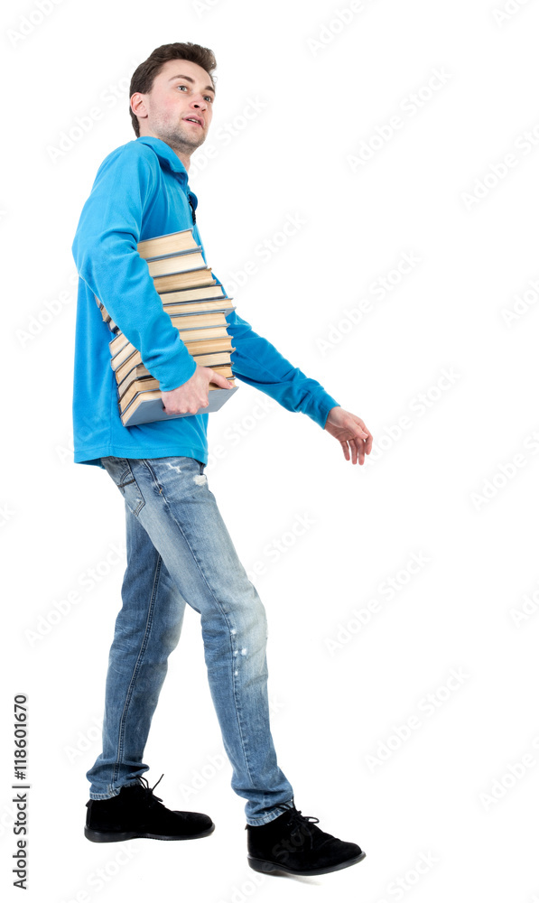 side view of going man carries a stack of books. walking young guy . Rear view people collection. backside view of person. Isolated over white background. side view of going man carries a stack of books. walking young guy . Rear view people collection. backside view of person. Isolated over white background.