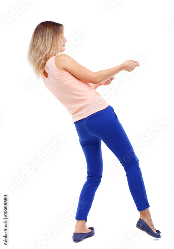 back view of standing girl pulling a rope from the top or cling to something. girl watching. Rear view people collection. backside view of person. Isolated over white background. The blonde in a