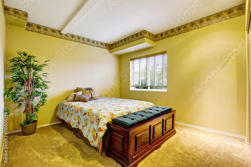 Bedroom interior with yellow walls and carpet floor