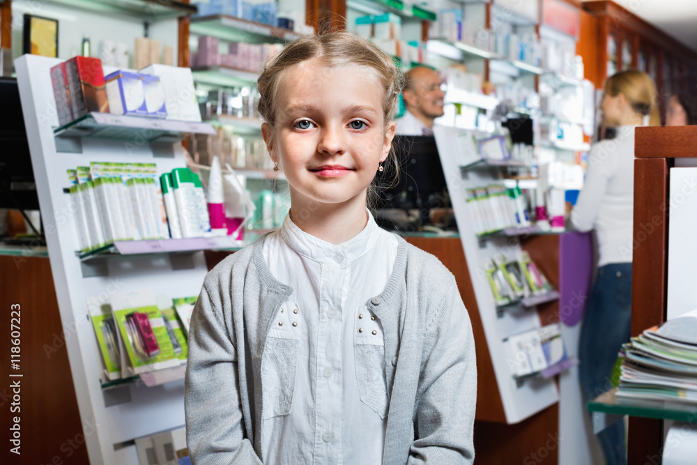 Little glad girl  in the pharmacy with parents and pharmacist