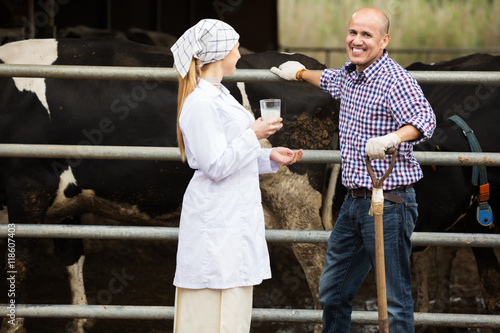 Veterinarian and farmer in cowshed
