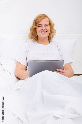 Young woman using a Tablet PC in bed.