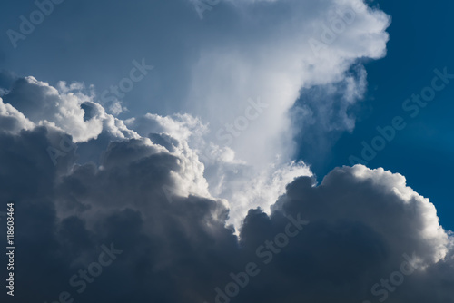 Closeup Cumulus clouds on blue sky with sun beam
