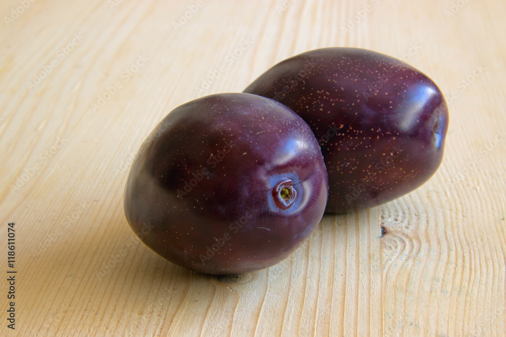 Two Plums Isolated on Wooden Background Two Plums Isolated on Wooden Background