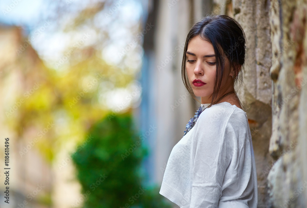 Attractive woman with red lips looks down while posing on the ol Attractive woman with red lips looks down while posing on the ol