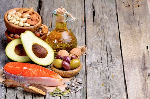 Selection of healthy fat sources on wooden background. Copyspace background.
