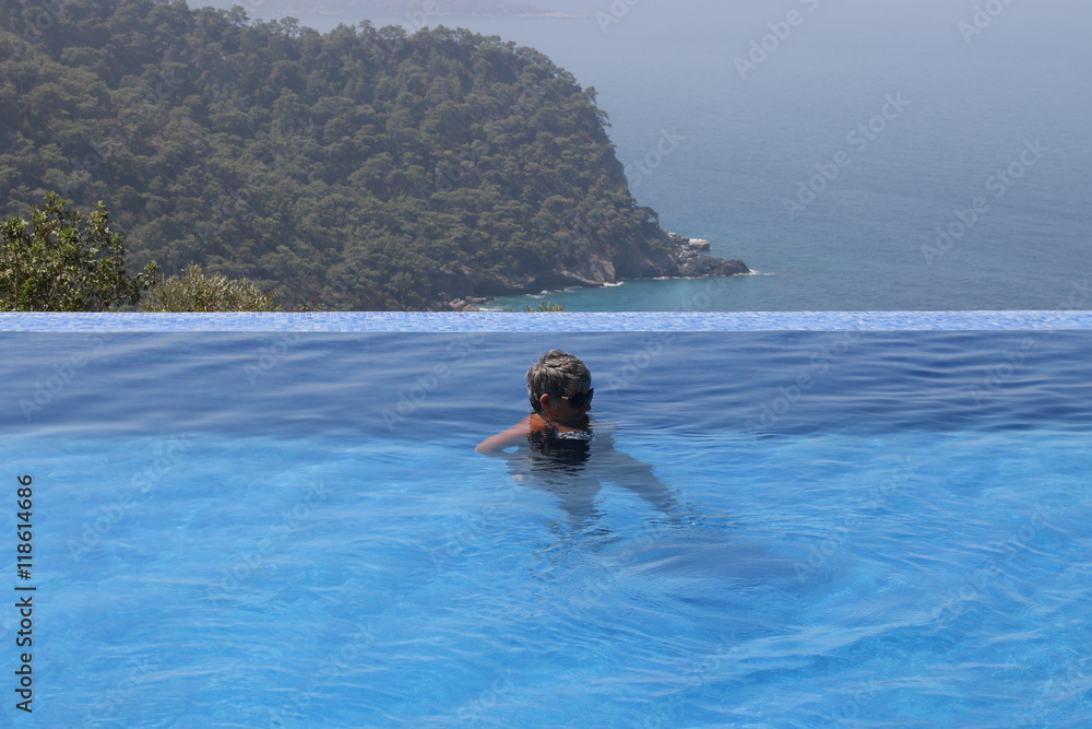 An english lady relaxing in an infinity pool while on vacation , 2016