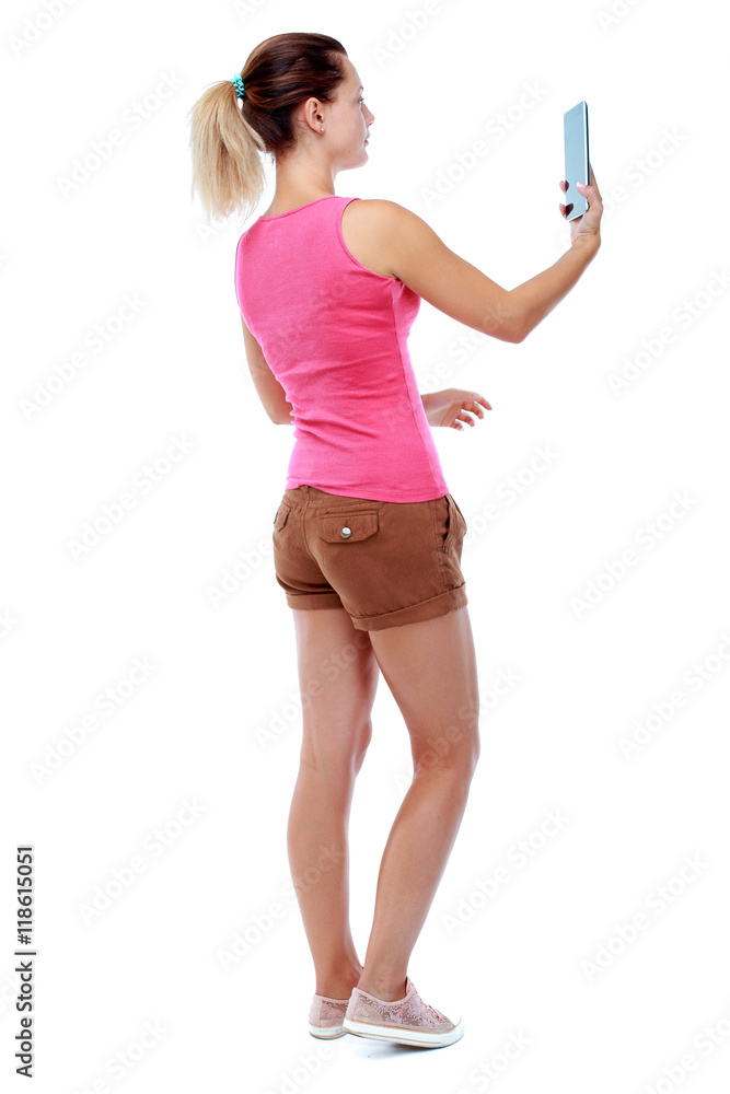 back view of standing young beautiful woman using a mobile phone. girl watching. Rear view people collection. backside view of person. Isolated over white background. Sport blond in brown shorts back view of standing young beautiful woman using a mobile phone. girl watching. Rear view people collection. backside view of person. Isolated over white background. Sport blond in brown shorts