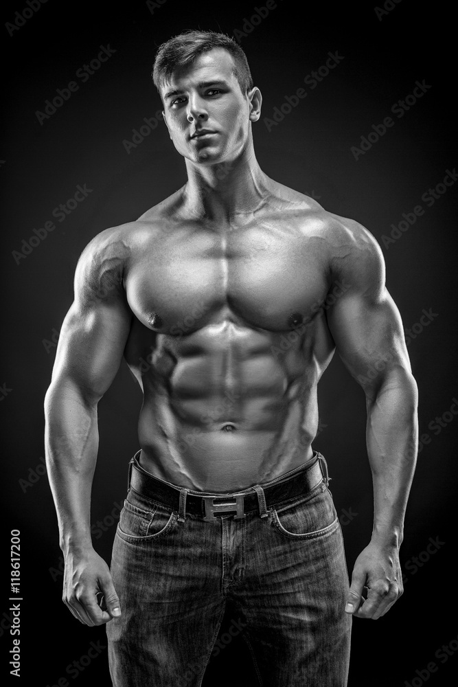 Muscular bodybuilder guy doing posing over black background Muscular bodybuilder guy doing posing over black background