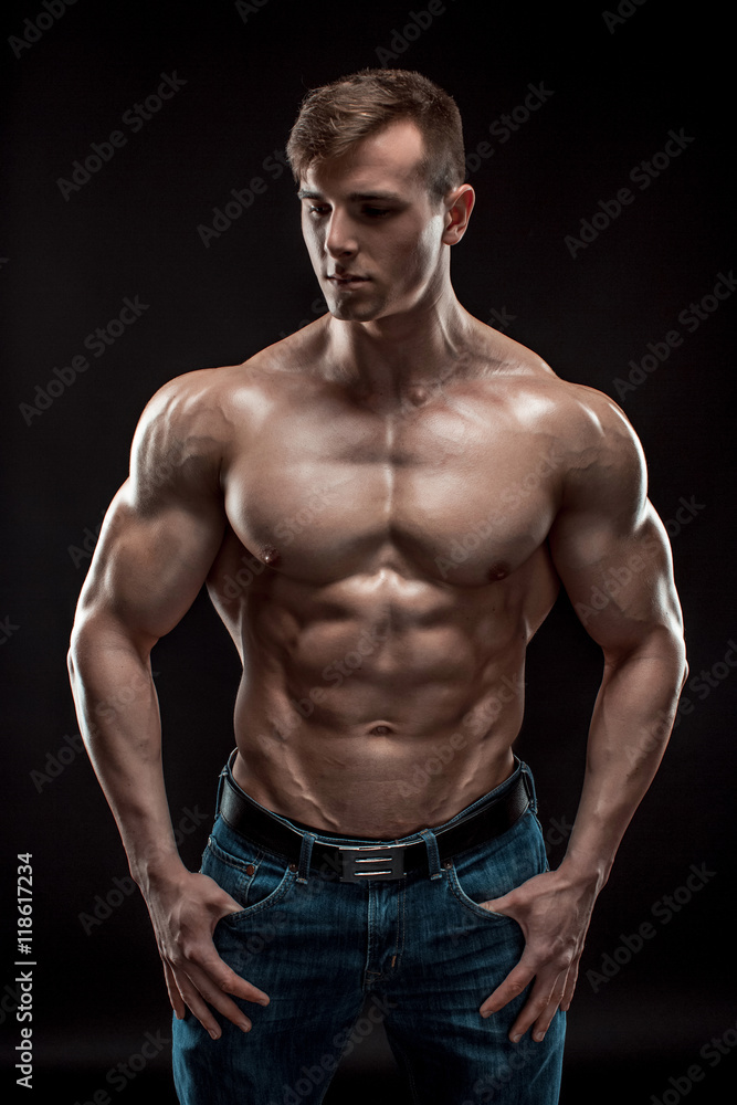 Muscular bodybuilder guy doing posing over black background