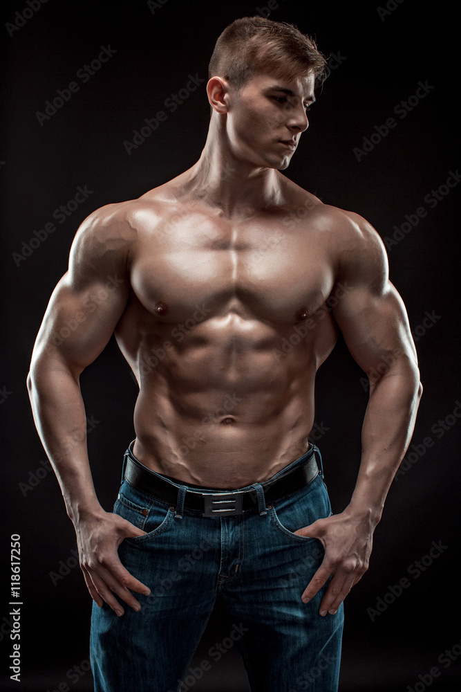 Muscular bodybuilder guy doing posing over black background Muscular bodybuilder guy doing posing over black background