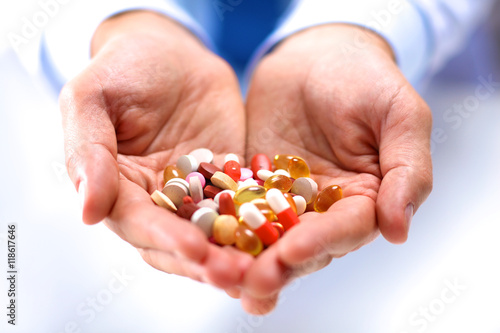 doctor holds the patient's hand with pills