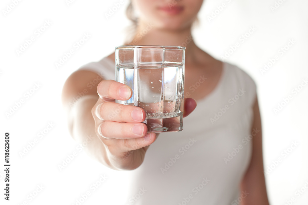 A glass of water in girl hands isolated A glass of water in girl hands isolated
