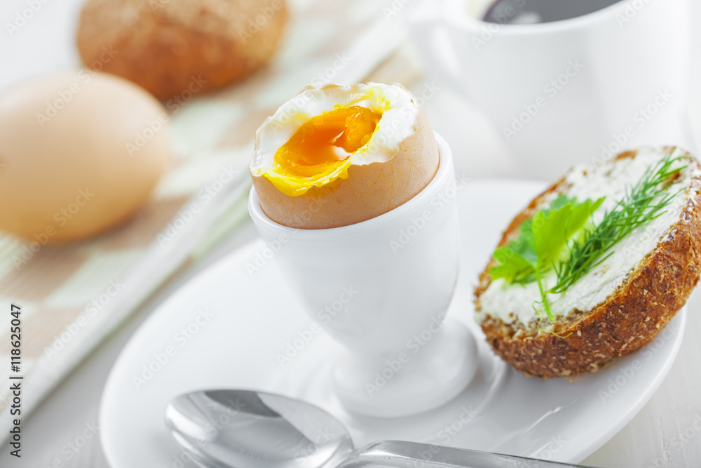 Perfect soft boiled egg, bread and butter, cup of coffee for delicious healthy breakfast on a table. Traditional homemade food. Perfect soft boiled egg, bread and butter, cup of coffee for delicious healthy breakfast on a table. Traditional homemade food.