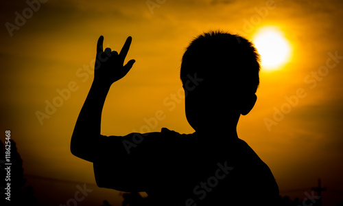 Abstract photo sunset orange evening light, a boy holds hands as a sign of showing love.