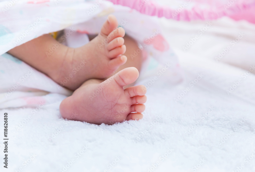 Close up little feet of baby newborn covered in white towel selective focus Close up little feet of baby newborn covered in white towel selective focus